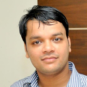 Portrait of a man with short black hair wearing a striped shirt.