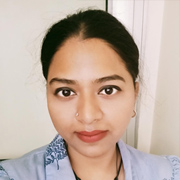Portrait of a woman with dark hair tied back, wearing a blue shirt, and a slight smile.