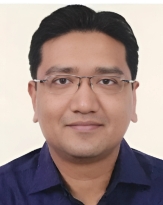 Portrait of a professional man wearing glasses and a dark shirt.