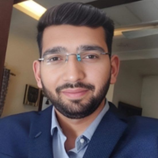 A professional headshot of a young man wearing glasses and a suit.