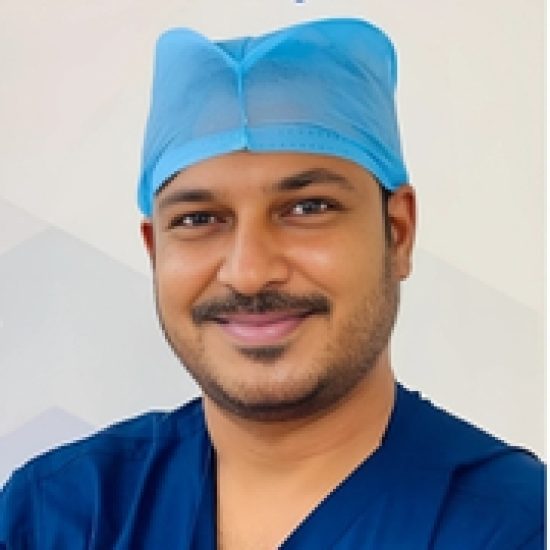 A smiling medical professional in surgical scrubs and a blue cap.